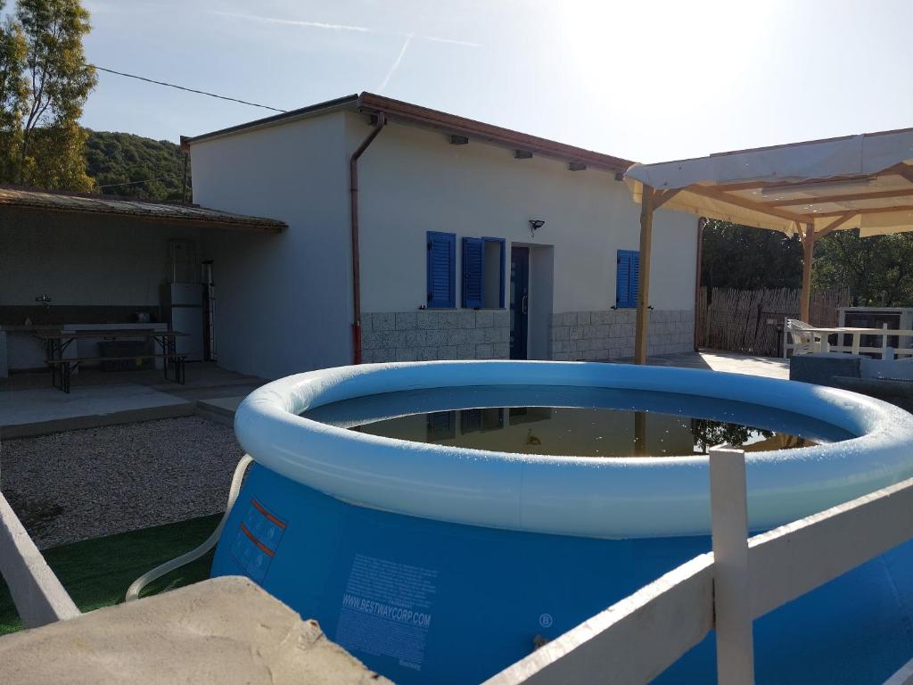 西尼斯科拉CASA LUCIA , ricarica auto elettrica GRATUITA的坐在房子前面的大蓝色浴缸