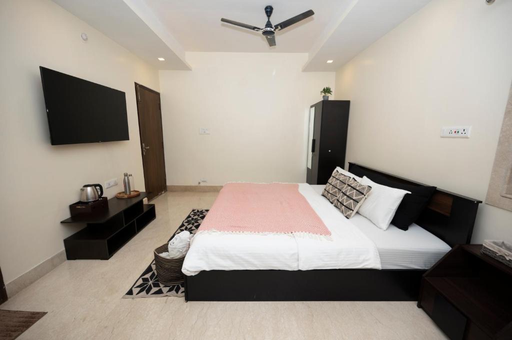 加尔各答Lakeside Suites的一间卧室配有一张大床和一台平面电视
