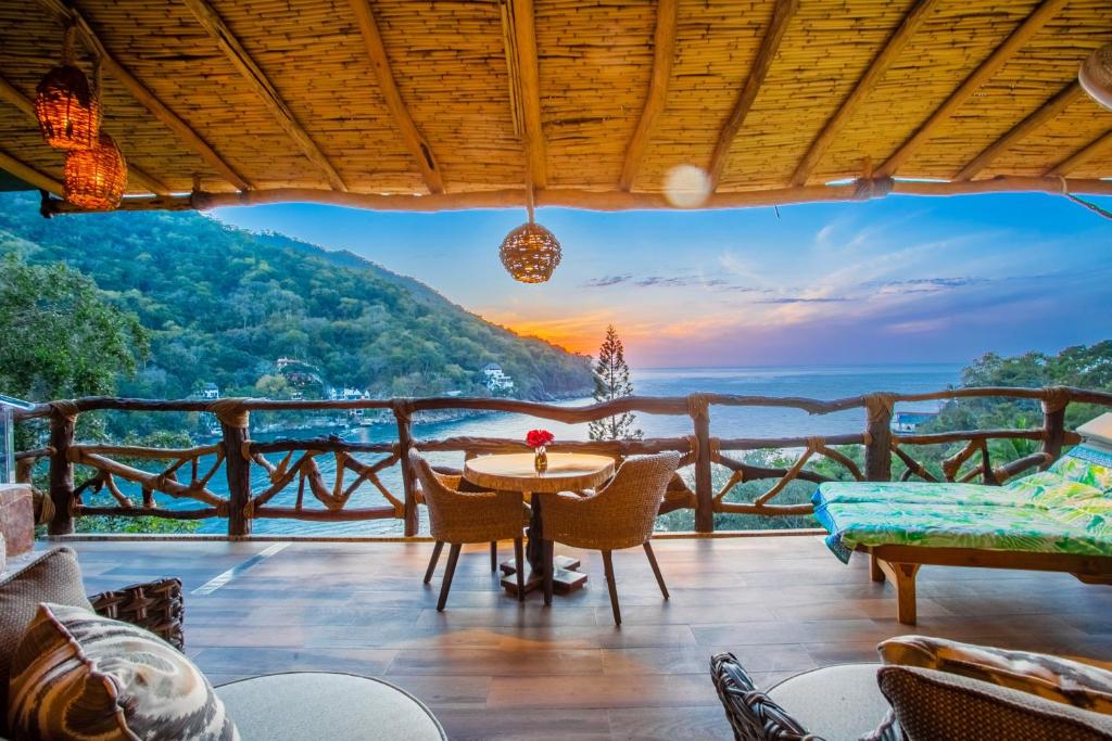 巴亚尔塔港Villa Lala Boutique Hotel Adults Only的房屋的甲板上设有桌椅,享有风景。