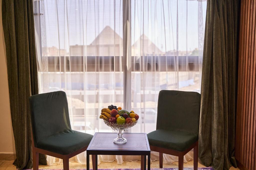 开罗New Pyramid Front Hotel的窗前桌子上的水果瓶