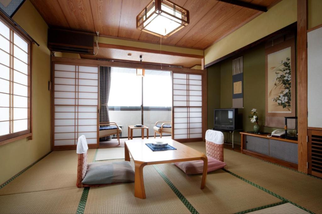 妙高Kofukan - Vacation STAY 64890v的客厅配有桌子和电视