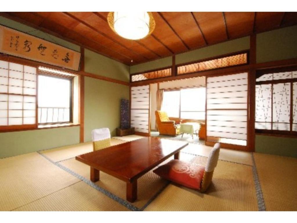 妙高Kofukan - Vacation STAY 67971v的客厅配有桌椅和窗户。