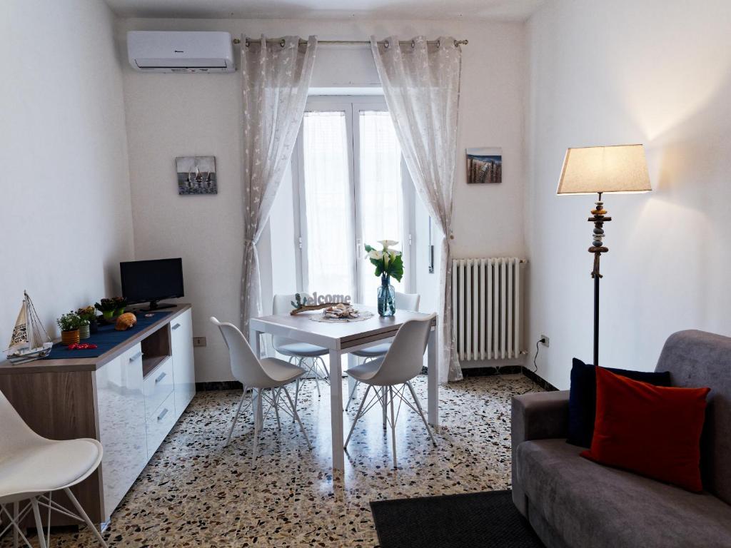 圣贝内代托-德尔特龙托Appartamento Nautes的客厅配有白色的桌子和椅子