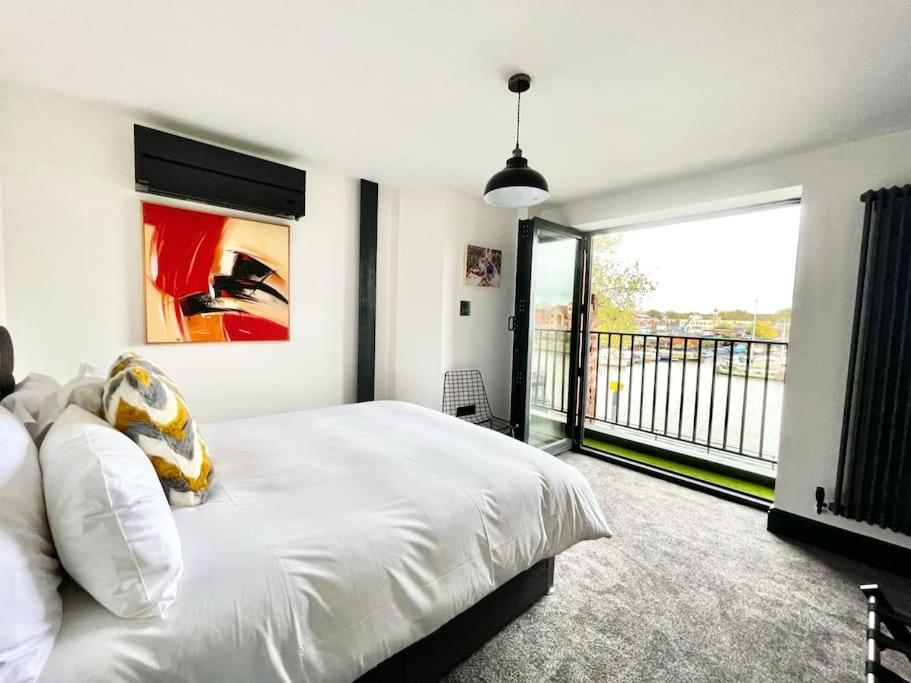 布里斯托Duplex Apartment Harbourside city centre的卧室设有白色的床和大窗户