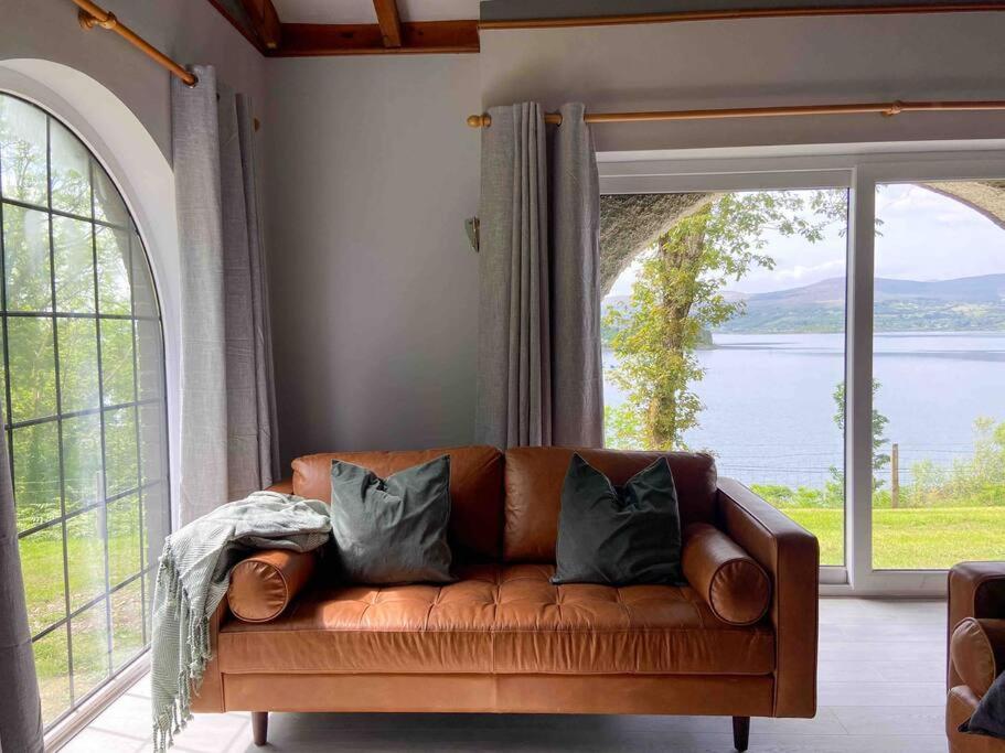 肯梅尔Sunset Cottage的客厅设有一张棕色沙发,配有大窗户