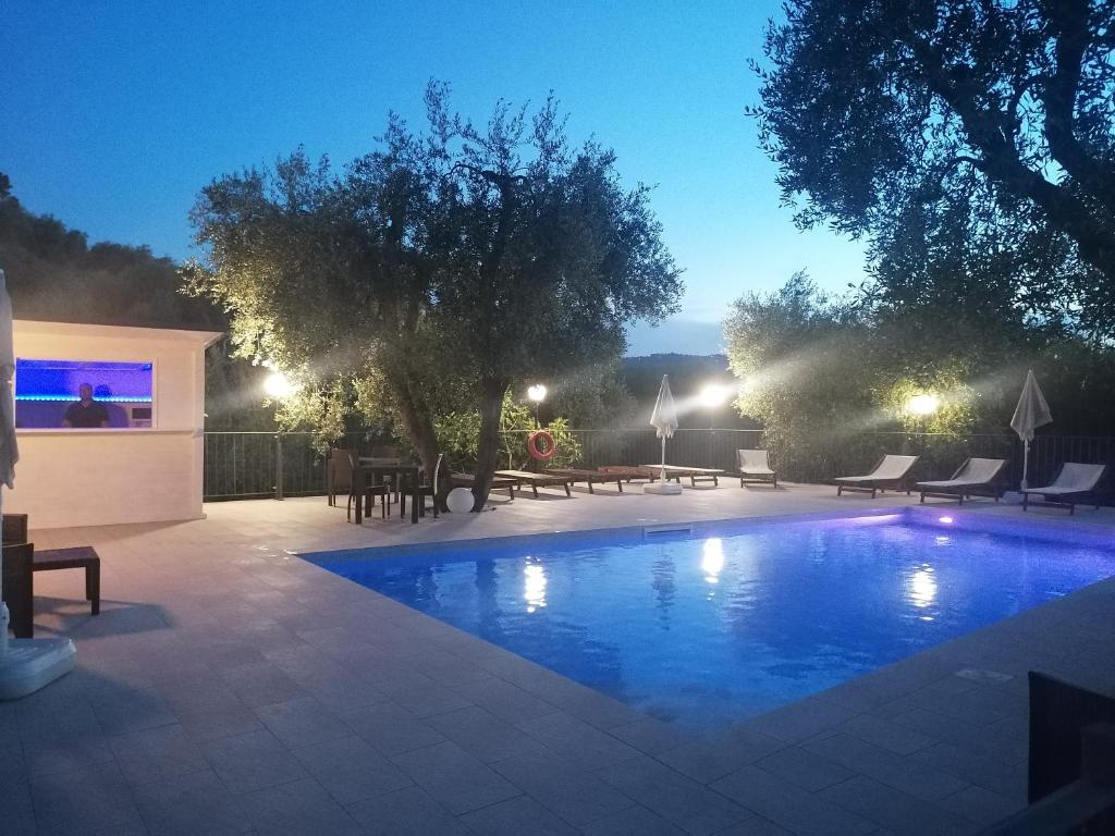 佩斯基奇Agriturismo Valle Dei Gelsi的一个带桌椅的夜间游泳池