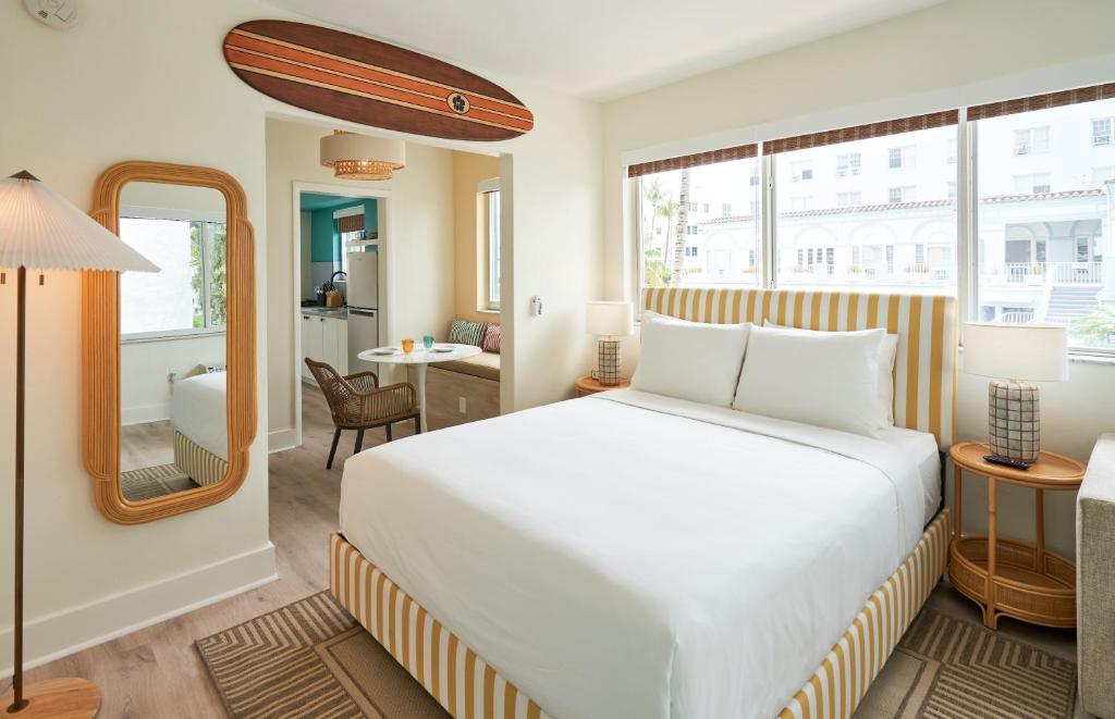 迈阿密海滩Aloha Fridays的卧室配有白色的床和镜子