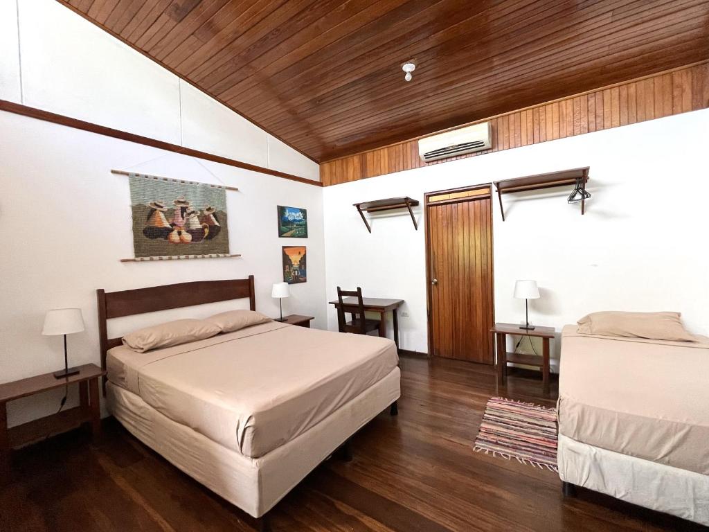 别霍港El Clan Hostel的一间卧室设有两张床和木制天花板
