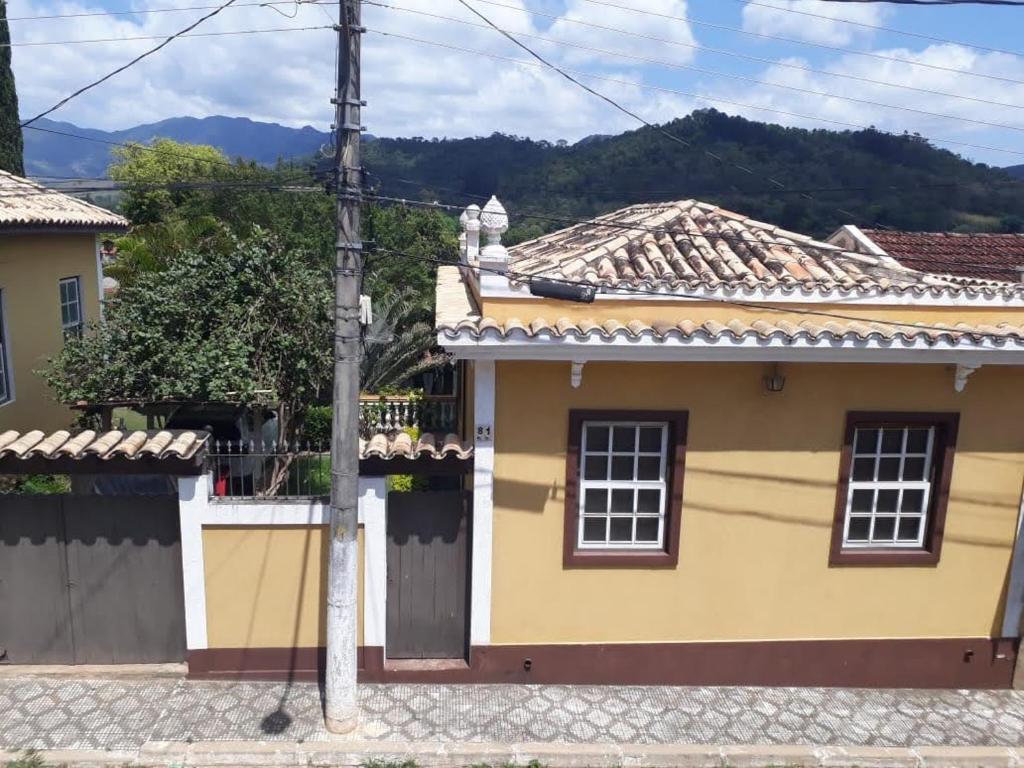 圣本图-杜萨普卡伊Mini Casarão的黄色房子,有栅栏和山峰