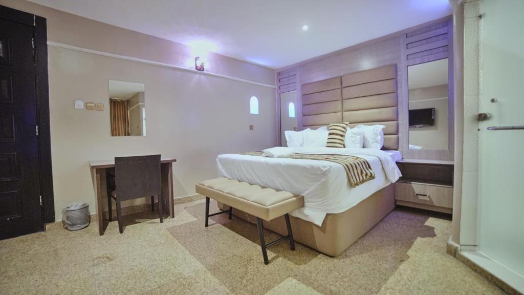 拉各斯Ikeja Airport View的一间大卧室,配有一张大床和一张书桌