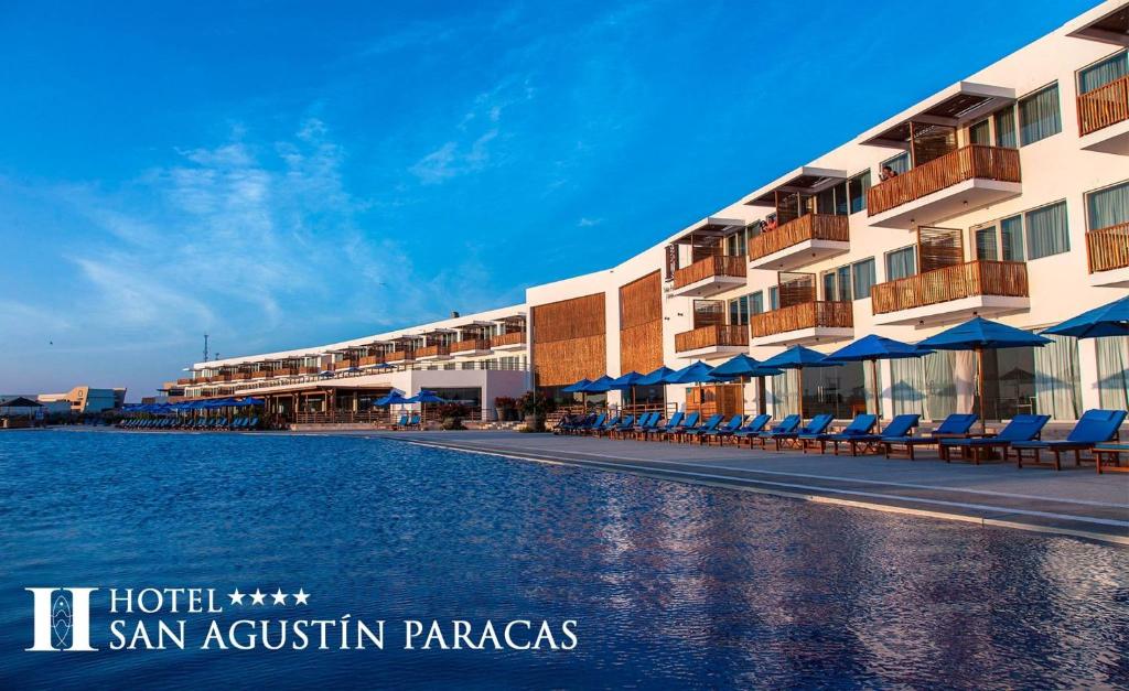帕拉卡斯圣奥古斯丁帕拉卡斯酒店的一座带椅子和水体的度假建筑