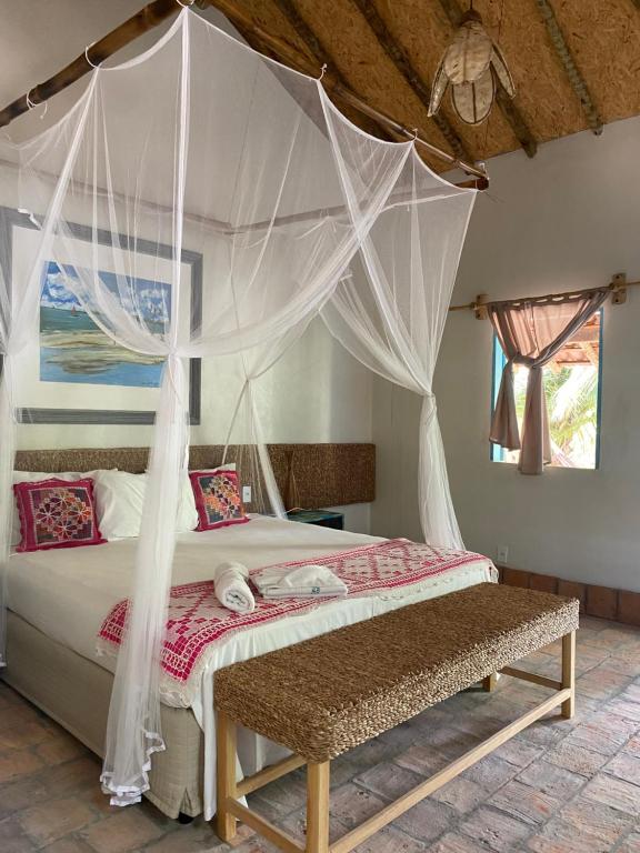 路易斯科雷亚Vilarejo Macapá Chalés的一间卧室配有一张带蚊帐的床