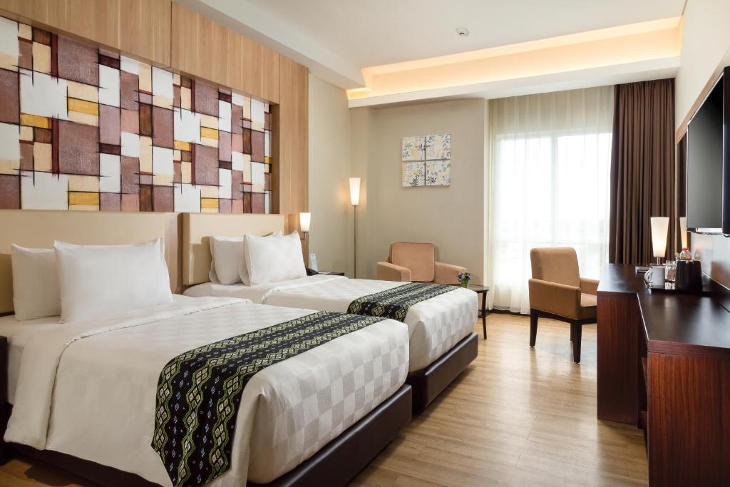班贾尔马辛BEST WORLD KINDAI HOTEL的酒店客房配有两张床和一张书桌