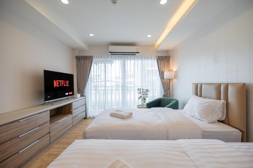 曼谷Exoresidence The Heart of Chinatown的酒店客房设有两张床和一台平面电视。
