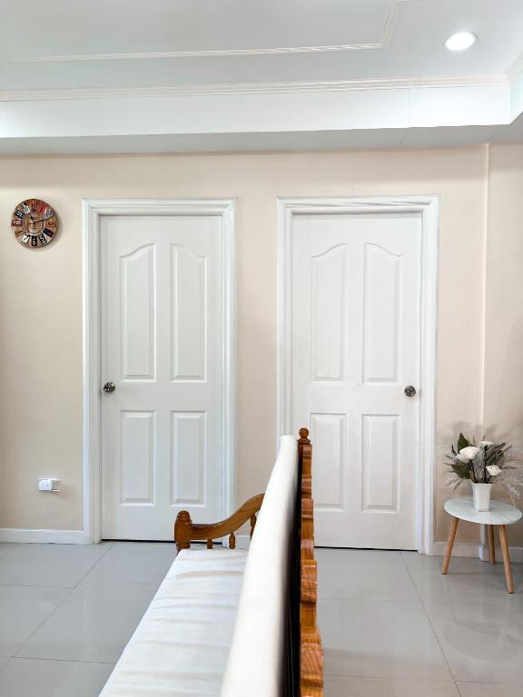 碧瑶Cozy Millenium House的白色客房内的两扇白色门,配有桌子