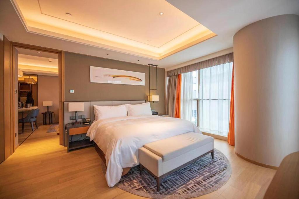 上海自在居珀瑞公寓(国家会展中心店)的一间带大床的卧室和一间带书桌的房间