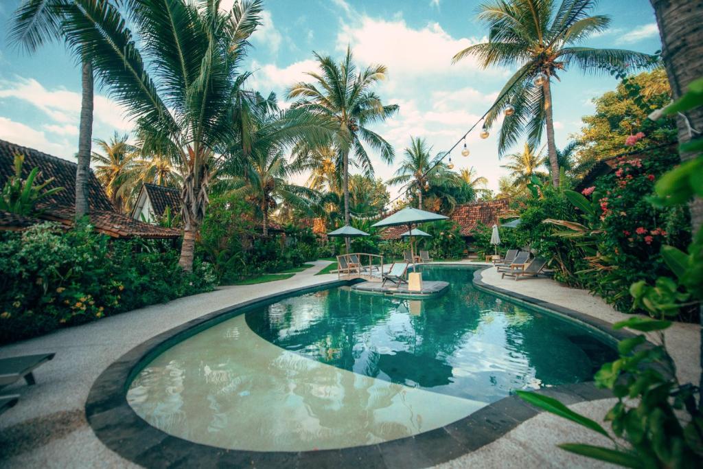 吉利特拉旺安椰子花园度假酒店的棕榈树度假村内的游泳池