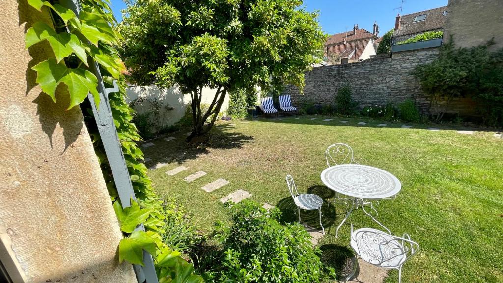 博讷MonCoeur, maison et jardin à 700 m des Hospices de Beaune的庭院内带桌椅的花园