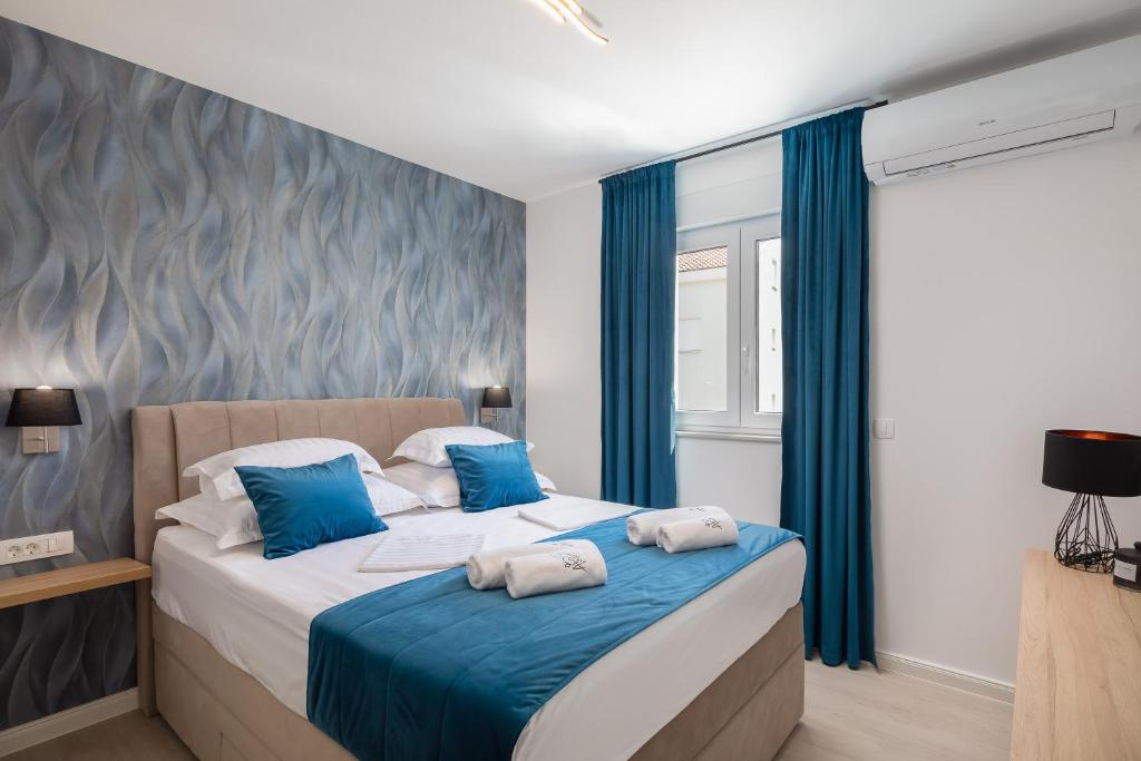 普罗马尼亚A&D Deluxe apartments Dani with swimming pool的一间卧室配有一张带蓝色窗帘的大床