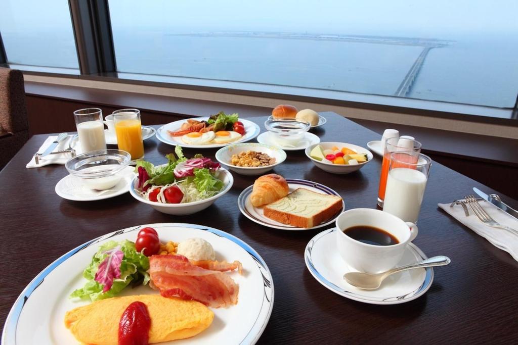 泉佐野Odysis Suites Osaka Airport Hotel的餐桌,早餐盘和饮料