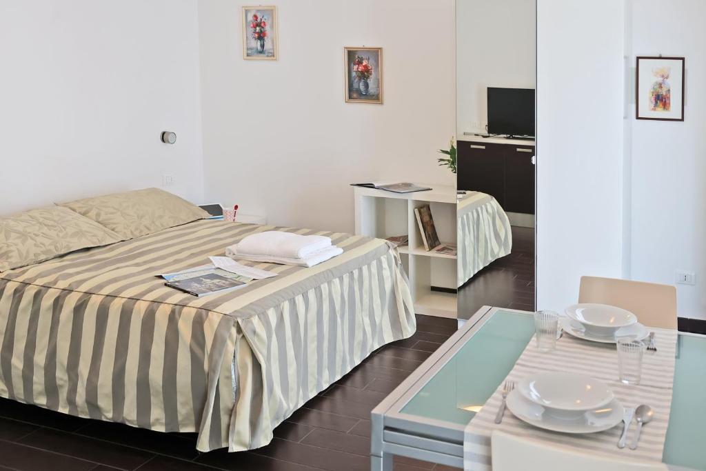 里米尼Casa Vacanze Aurora Centro的一间卧室配有床和一张桌子,上面有盘子