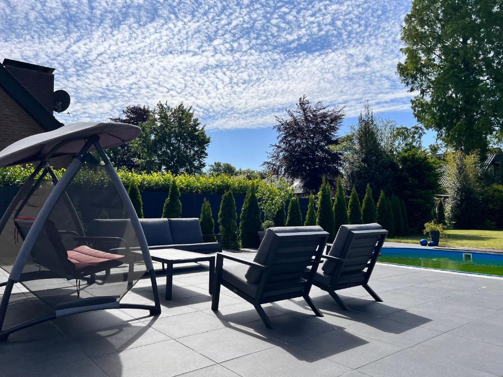 居特斯洛LUXUS-RelaxDays-Apartments的庭院配有桌椅和遮阳伞。