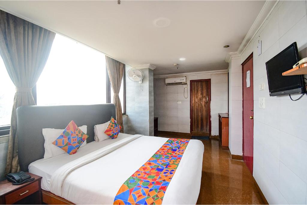 SaluaFabHotel Raj Darbar的卧室配有一张白色大床