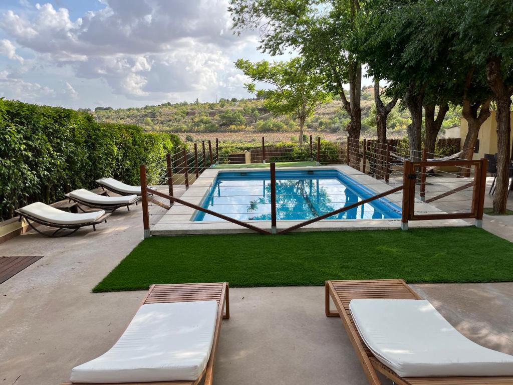 巴尔德佩尼亚斯Casa rural La Quinta De Lara的游泳池旁设有躺椅