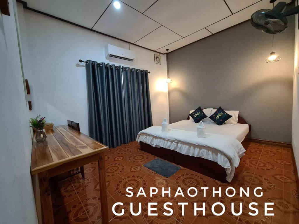 万荣Saphaothong guesthouse的酒店客房,设有一张床和一个窗口,提供“综合症”问卷