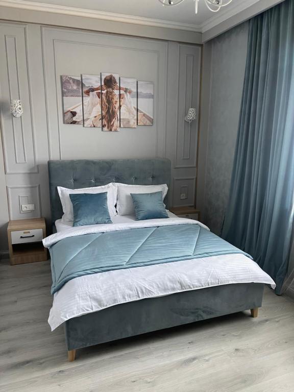 阿拉木图Aura Almaty的一间卧室配有蓝色和白色床单