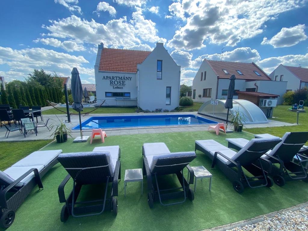 雷德尼斯Apartmány ROSE Lednice的后院设有游泳池、椅子和房屋