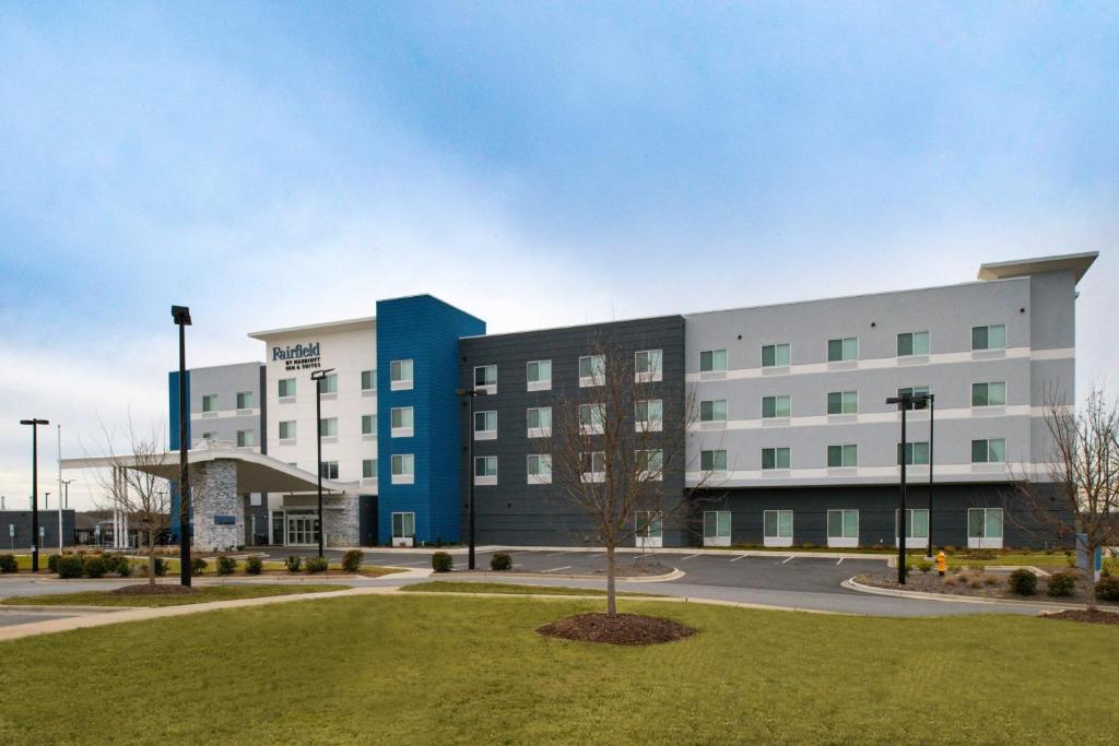 夏洛特Fairfield Inn & Suites by Marriott Charlotte University Research Park的前面有一棵树的白色大建筑