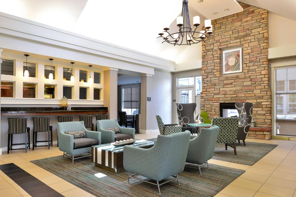 奥罗拉Residence Inn by Marriott Denver Airport at Gateway Park的大堂设有桌椅和壁炉。
