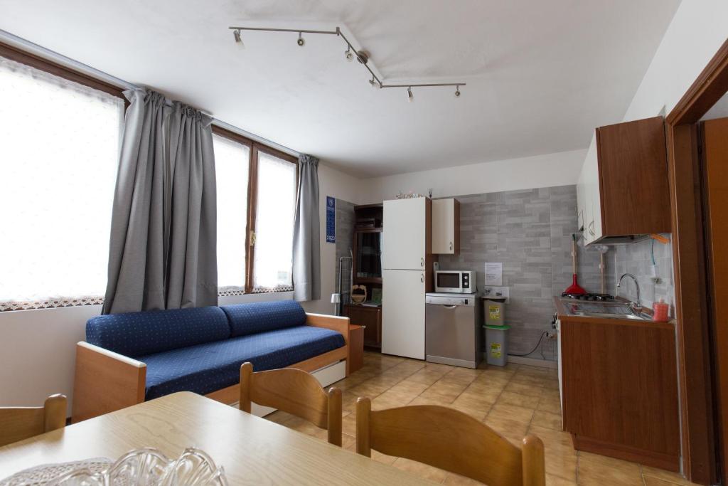 莫利纳迪莱德罗Casa Federica的一间带蓝色沙发的客厅和一间厨房