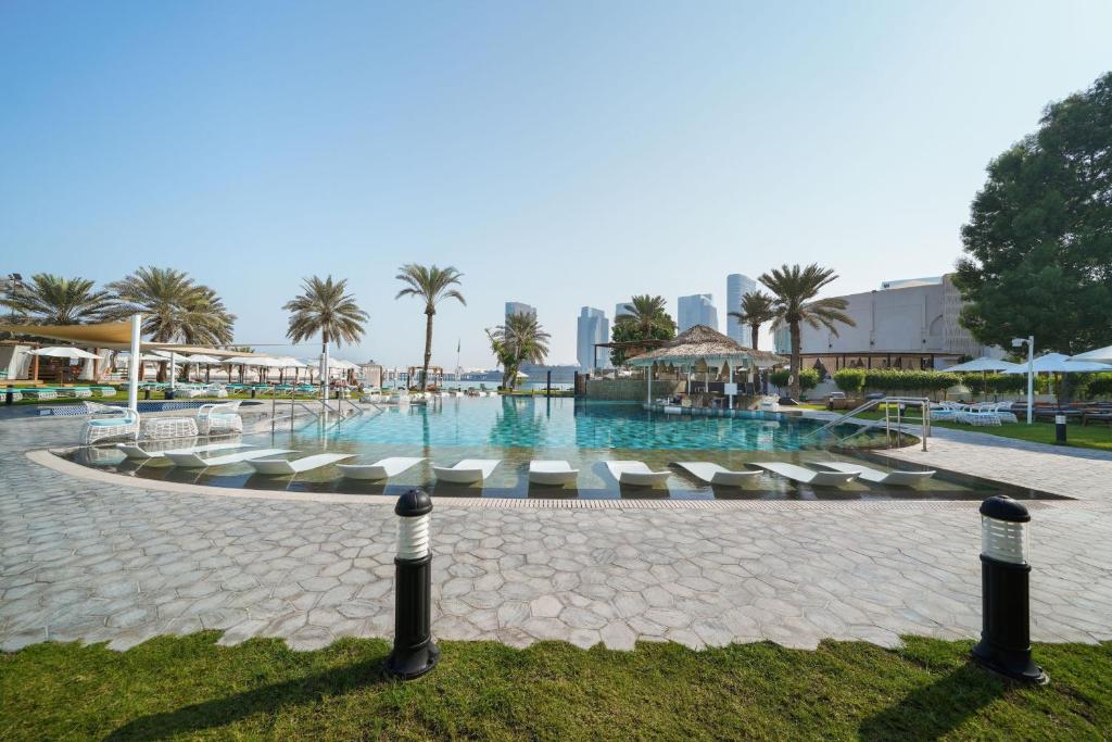 阿布扎比阿布扎比艾美假村酒店的一个带躺椅的大型游泳池,棕榈树