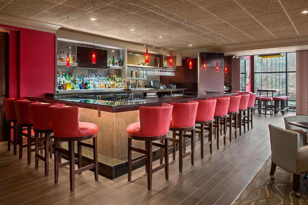 凯霍加福尔斯阿克伦凯霍加福尔斯喜来登套房酒店的餐厅内带红色椅子的酒吧