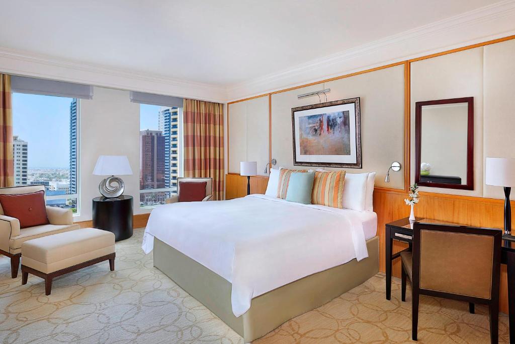 迪拜Ritz Carlton Residences DIFC Downtown Dubai的卧室配有一张白色大床和一张书桌