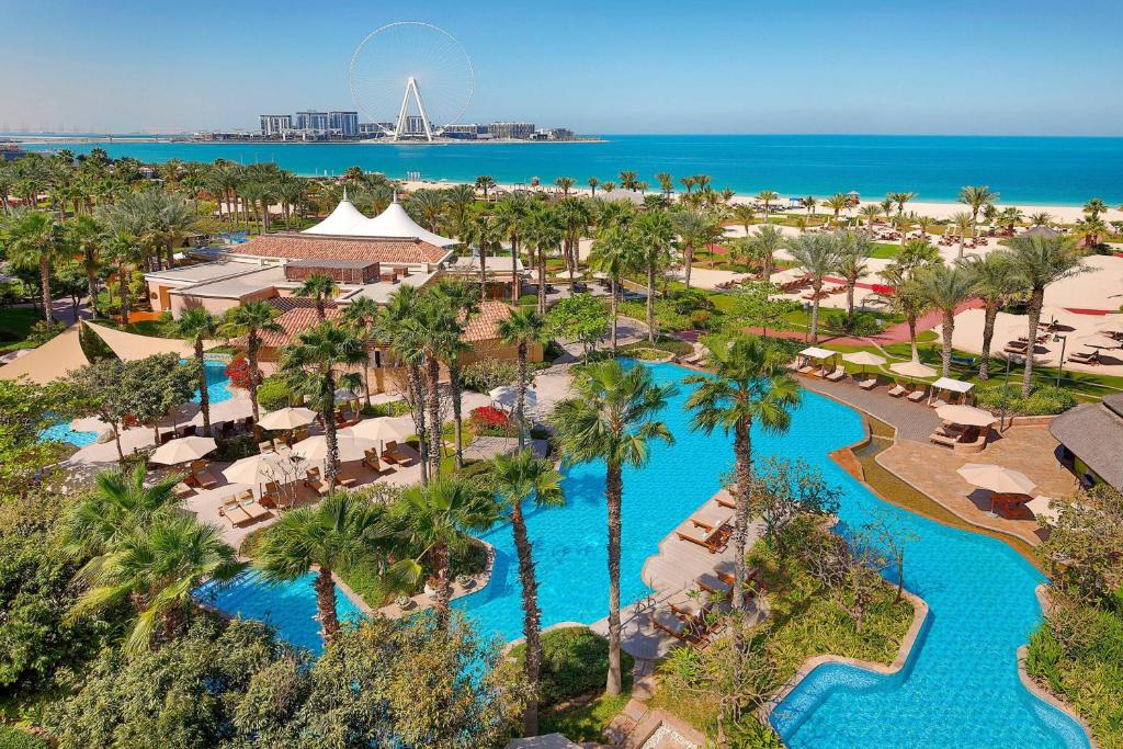 迪拜迪拜丽思卡尔顿酒店的享有带游泳池和海滩的度假村的空中景致