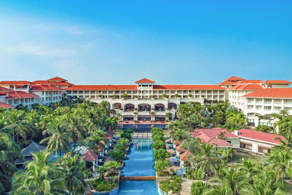 海口海口喜来登酒店的享有度假村的空中景致,设有游泳池和棕榈树