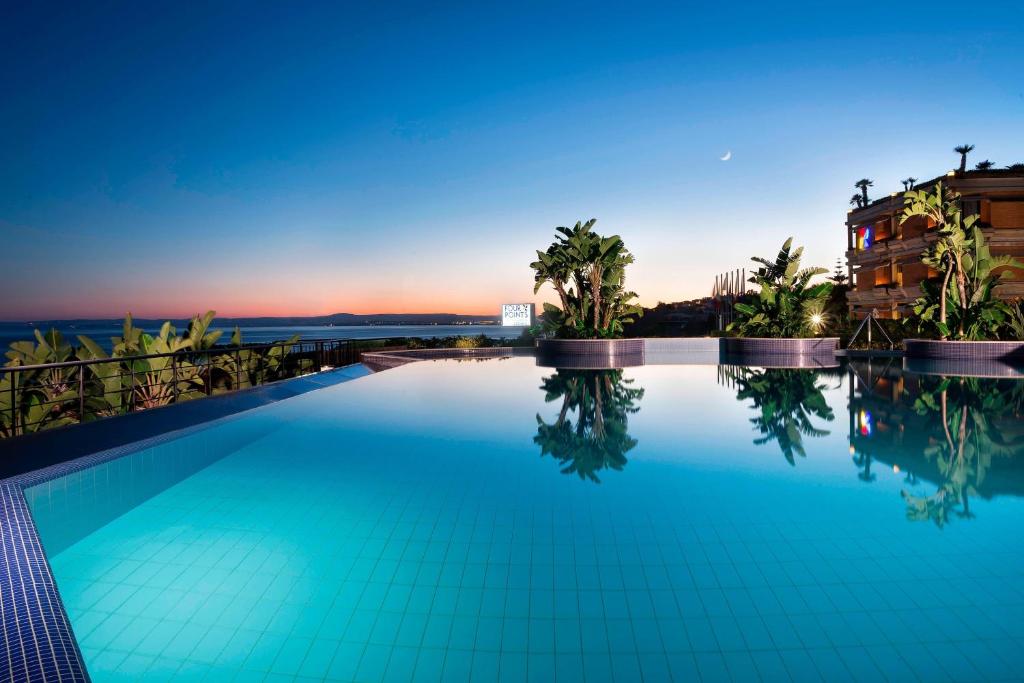 卡塔尼亚卡塔尼亚福朋喜来登酒店的一座享有日落美景的游泳池
