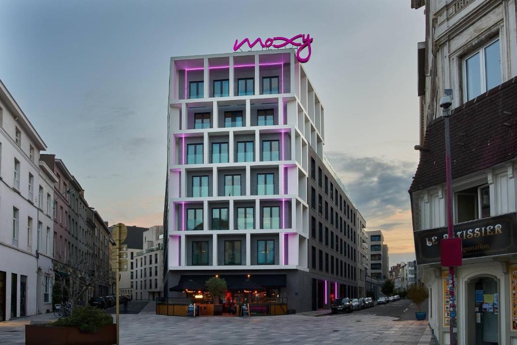 布鲁塞尔Moxy Brussels City Center的粉红色的建筑,上面有标志