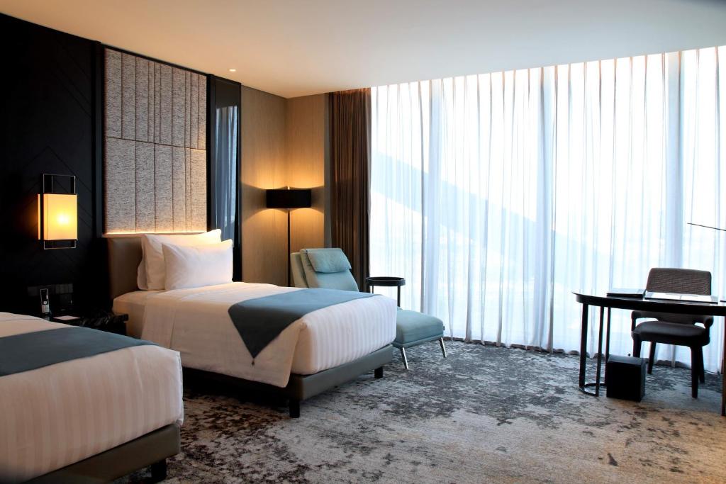 塞尔蓬JHL Solitaire Gading Serpong的酒店客房配有两张床和一张书桌