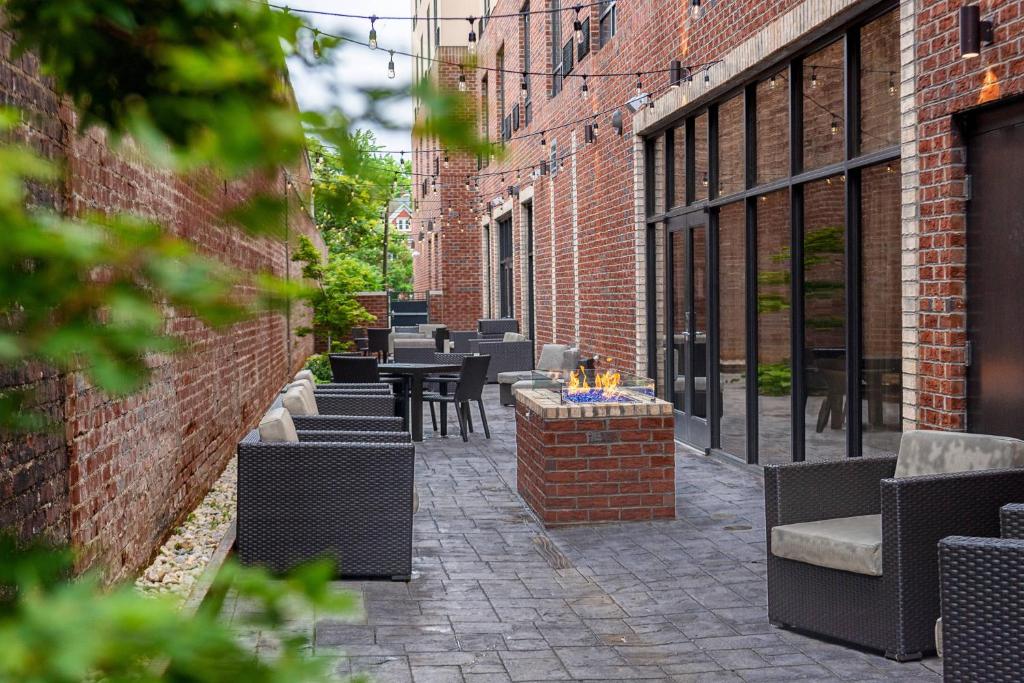 温斯顿·塞勒姆Courtyard Winston-Salem Downtown的砖砌建筑中带桌椅的庭院