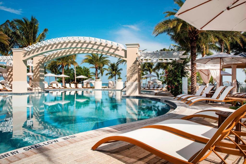 基拉戈基拉戈海滩度假酒店及Spa，傲途格精选酒店的一个带椅子和遮阳伞的度假村游泳池