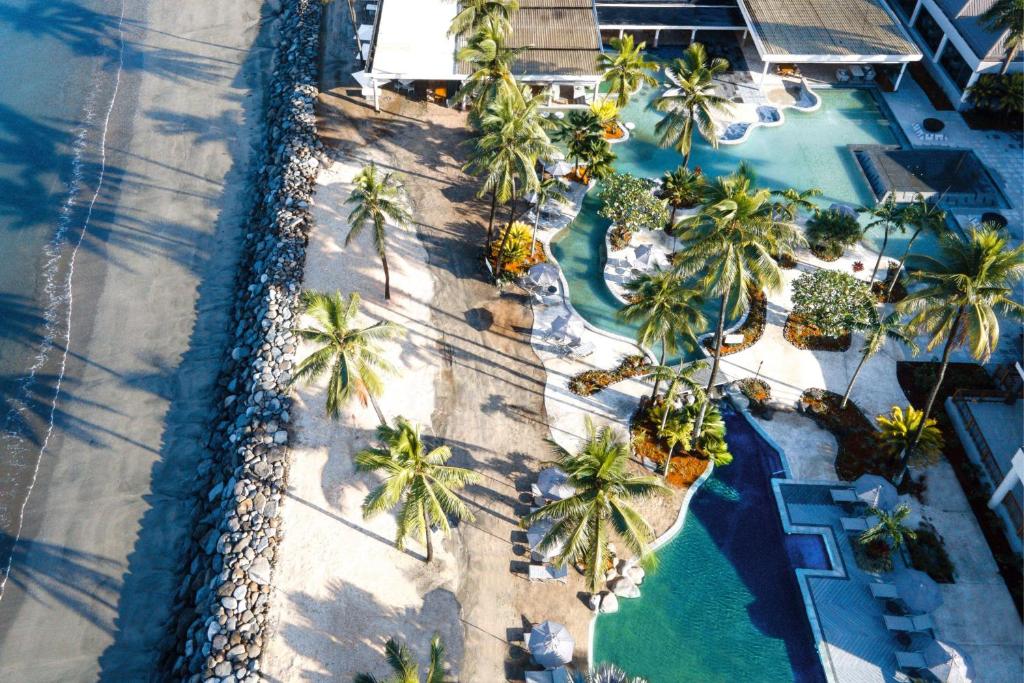 丹娜努Sheraton Fiji Golf & Beach Resort的棕榈树和水景度假村的空中景观