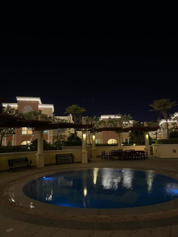 多哈Beachfront Luxury Apartment-The Home-Pearl Island的夜间在庭院里的一个游泳池