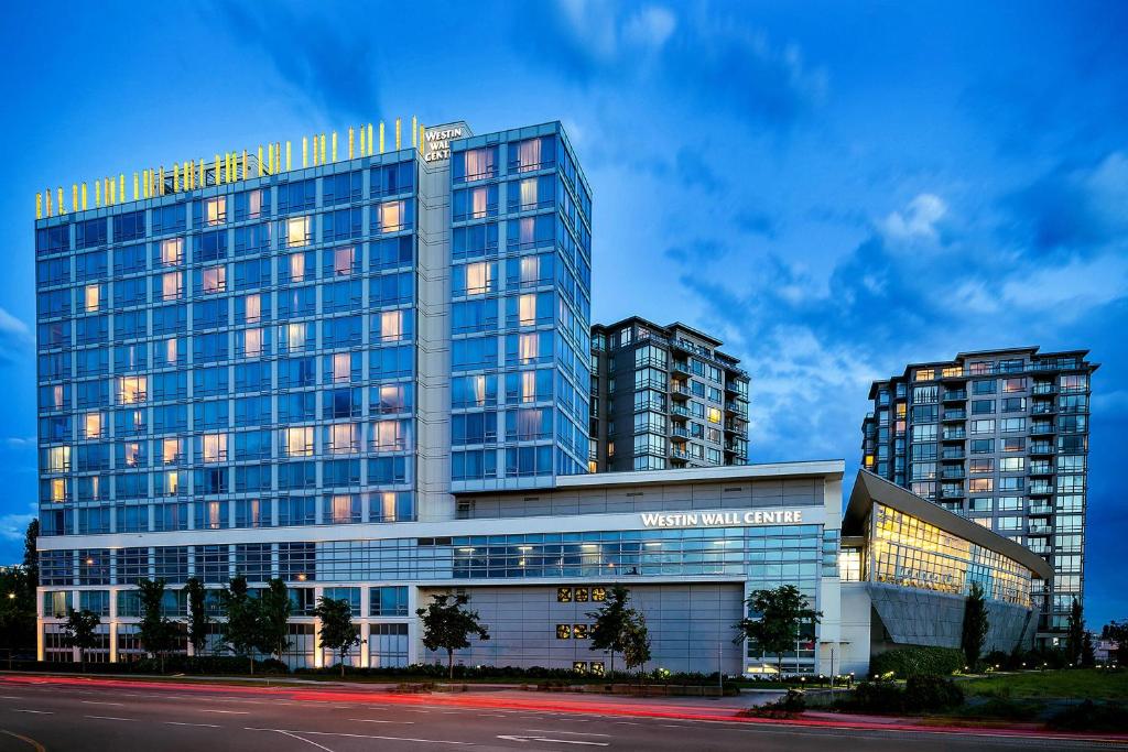 里士满The Westin Wall Centre, Vancouver Airport的一座大型玻璃建筑,两座高楼