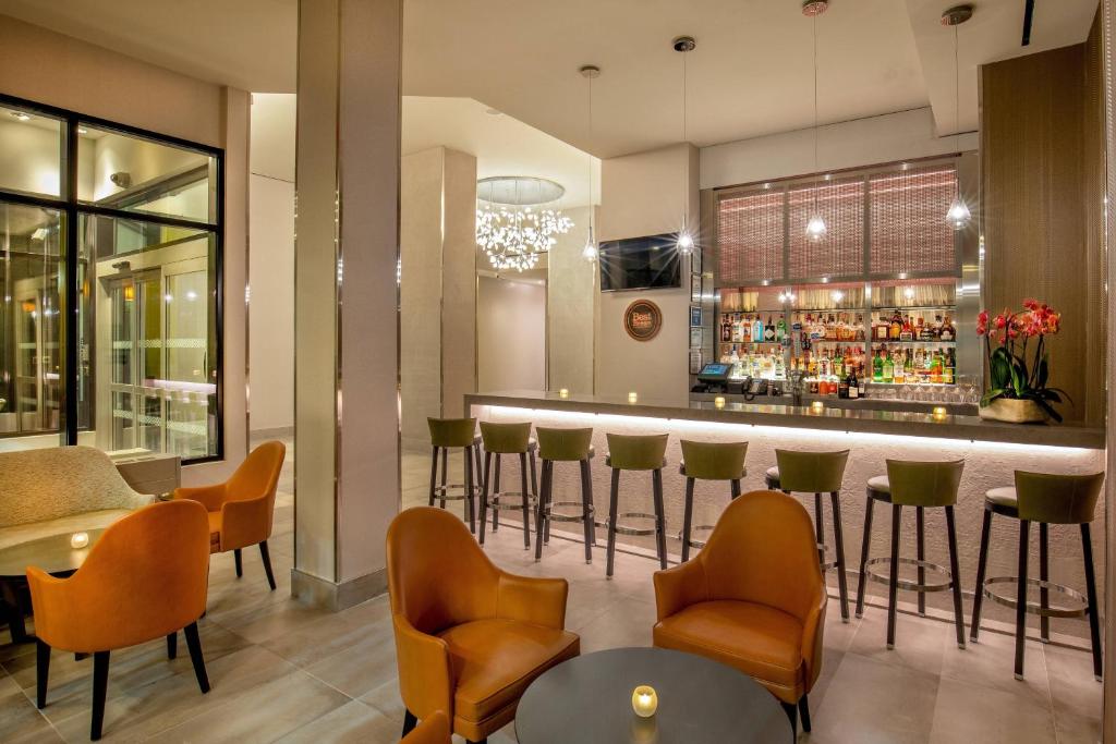 纽约市区时代广场福朋喜来登酒店的餐厅内的酒吧配有椅子和柜台