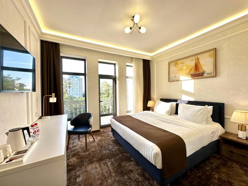 塔什干Garnet Hotel Tashkent的配有一张床和一张书桌的酒店客房