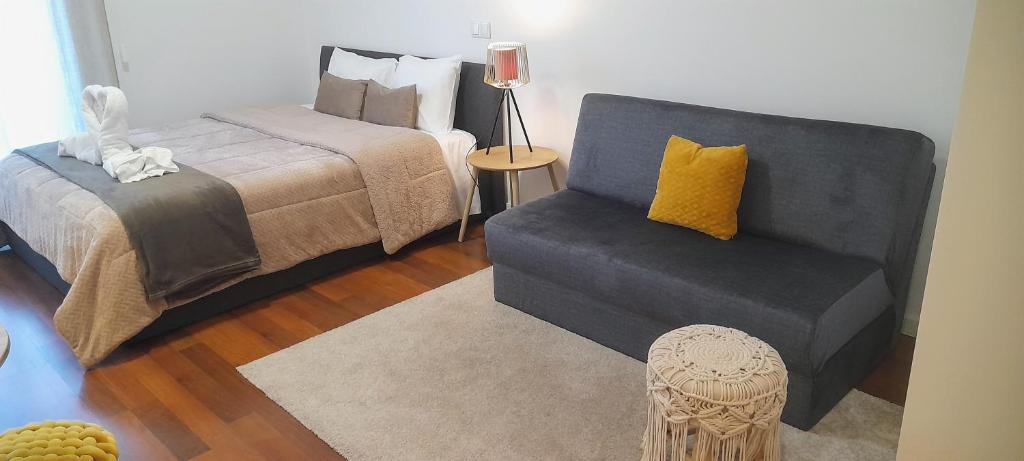 阿威罗Ria Palace Apartment的一间卧室配有一张床、一把椅子和一张床